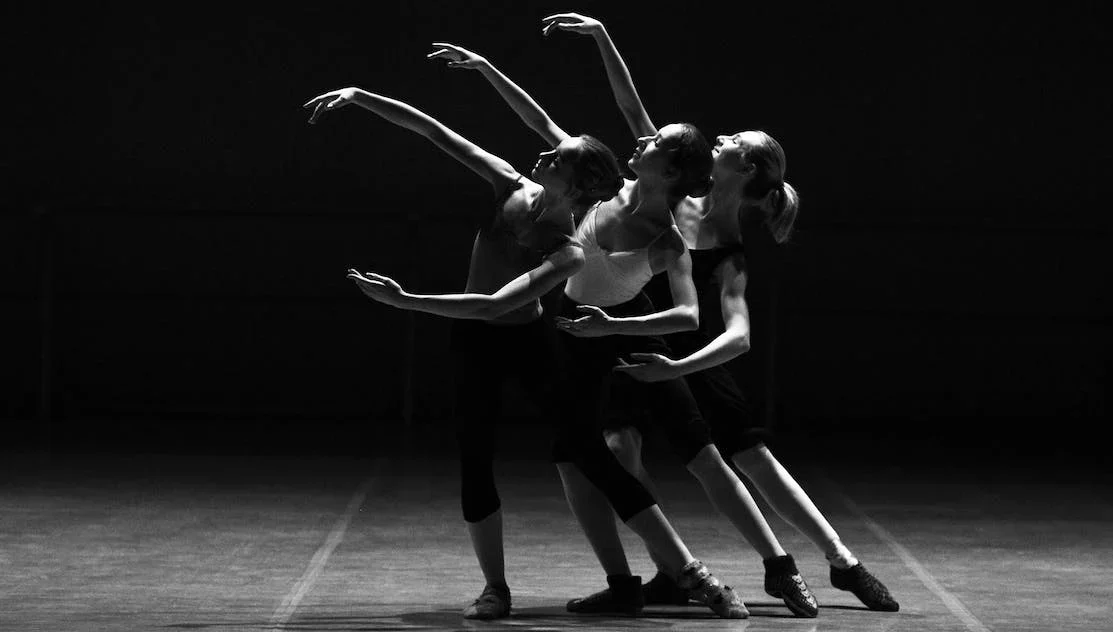 Tres chicas ejecutando una danza en un teatro
