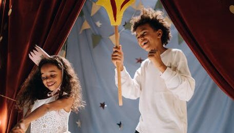 Dos niños felices actuando en un pequeño teatro infantil